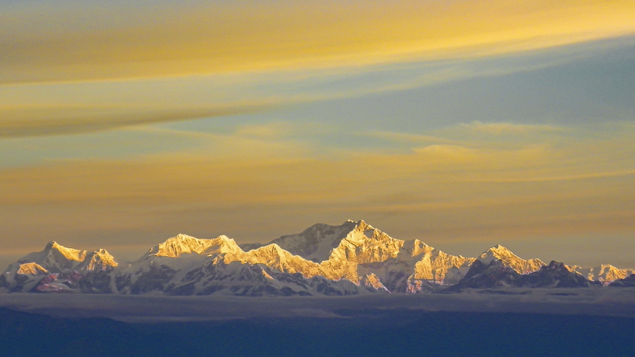 Snow-covered Himalayan peaks catching the first gold light of sunrise