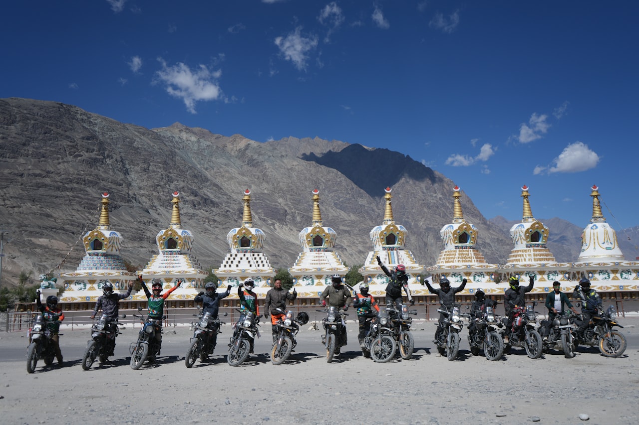 Riders pausing beside Buddhist stupas in the mountains of Ladakh