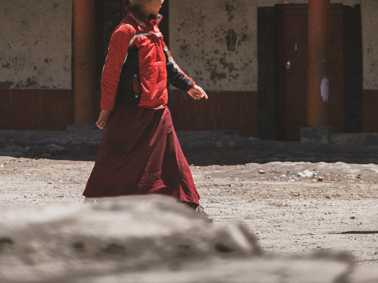 A monk walking past a monastery building in Ladakh, India